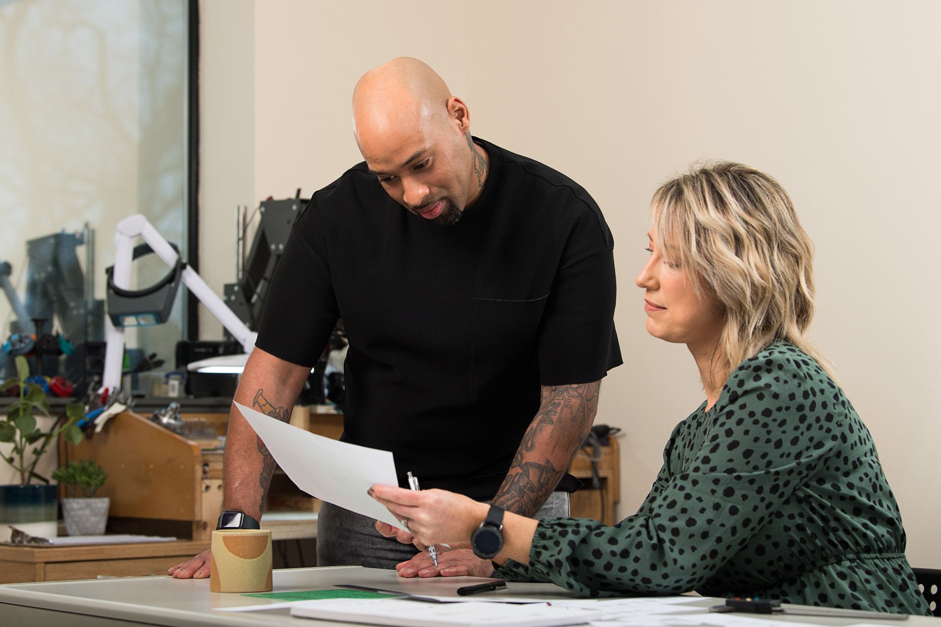 A horizontal shot of two colleagues in a modern workshop