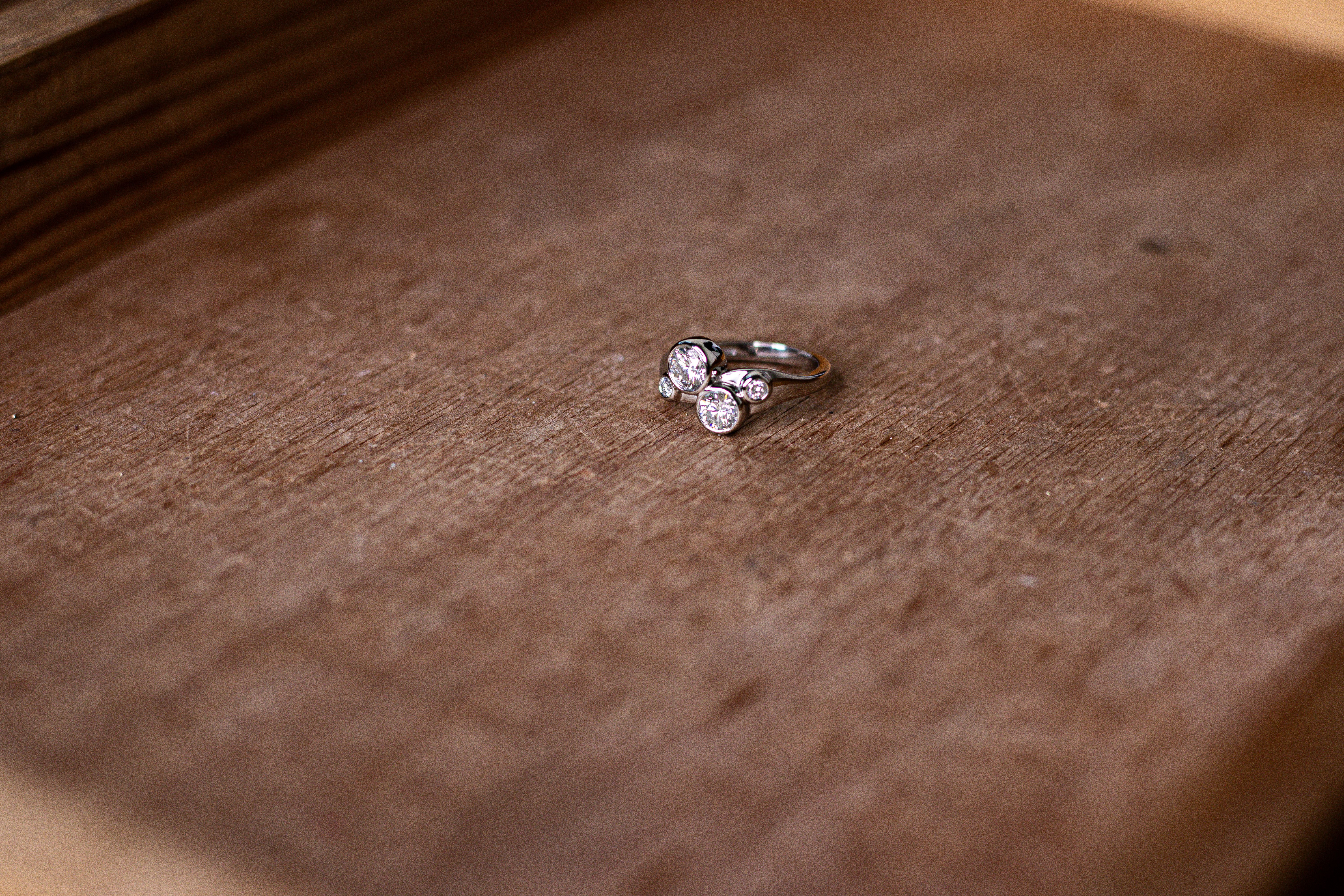 a diamond ring on top of a dark wood pallet