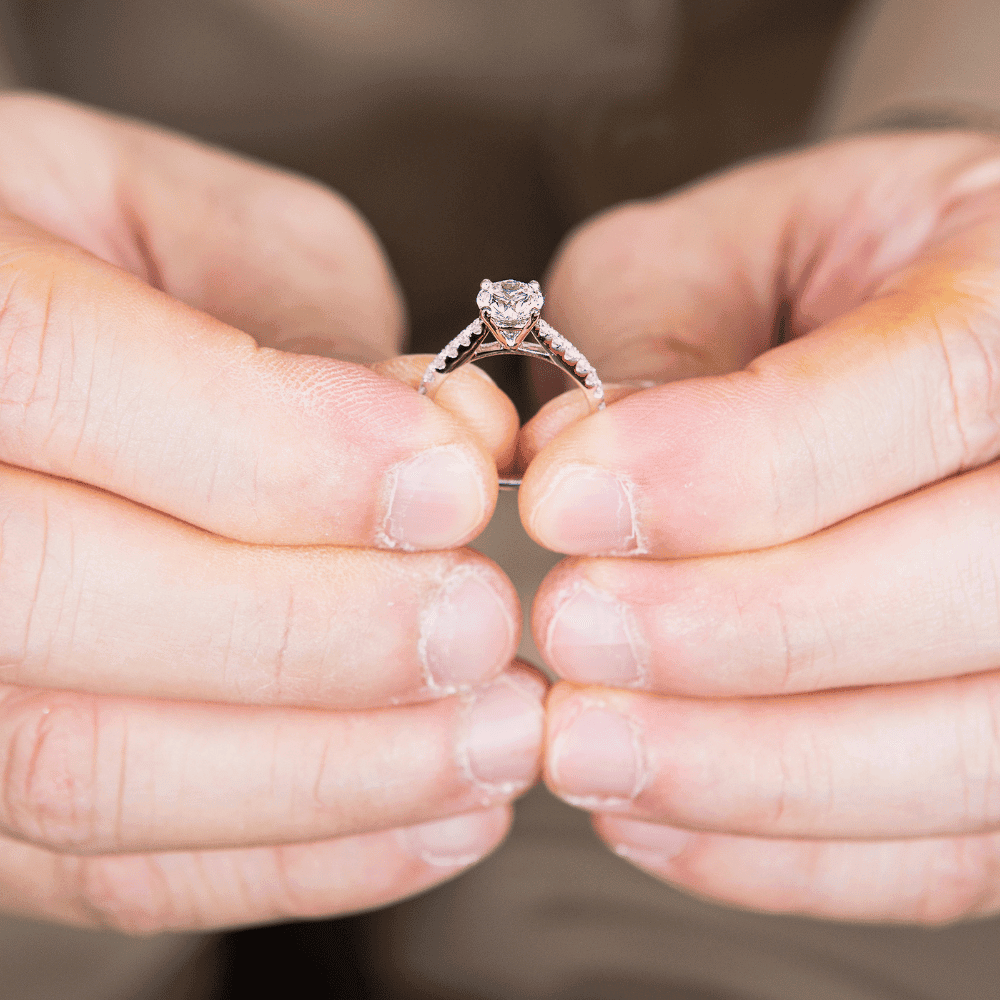 person holding simple diamond ring