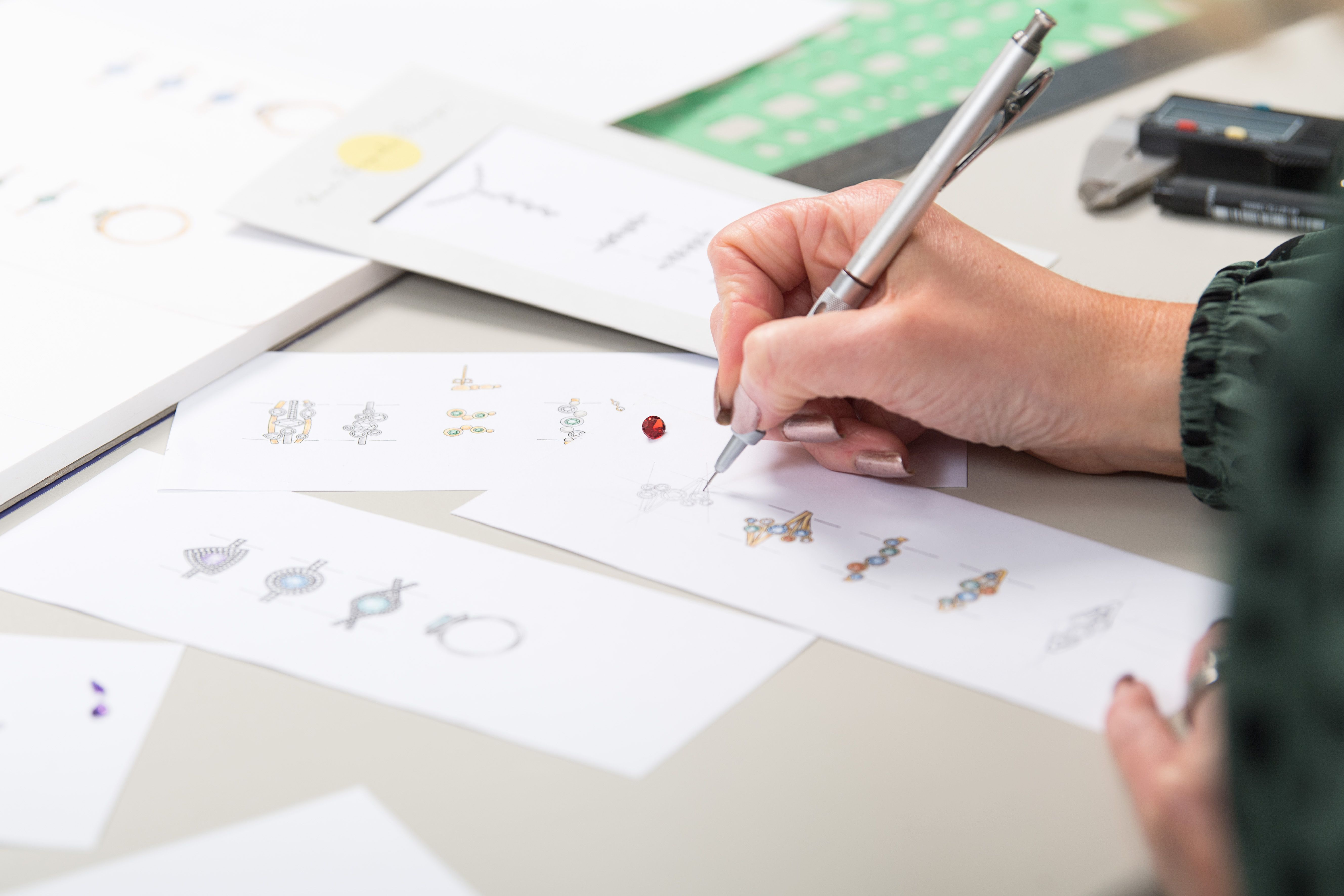 an individual working at hand drawing jewellery designs