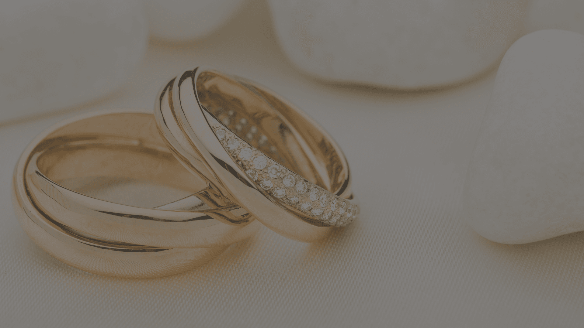 two rings of gold, one sat atop the other, one of which has diamonds